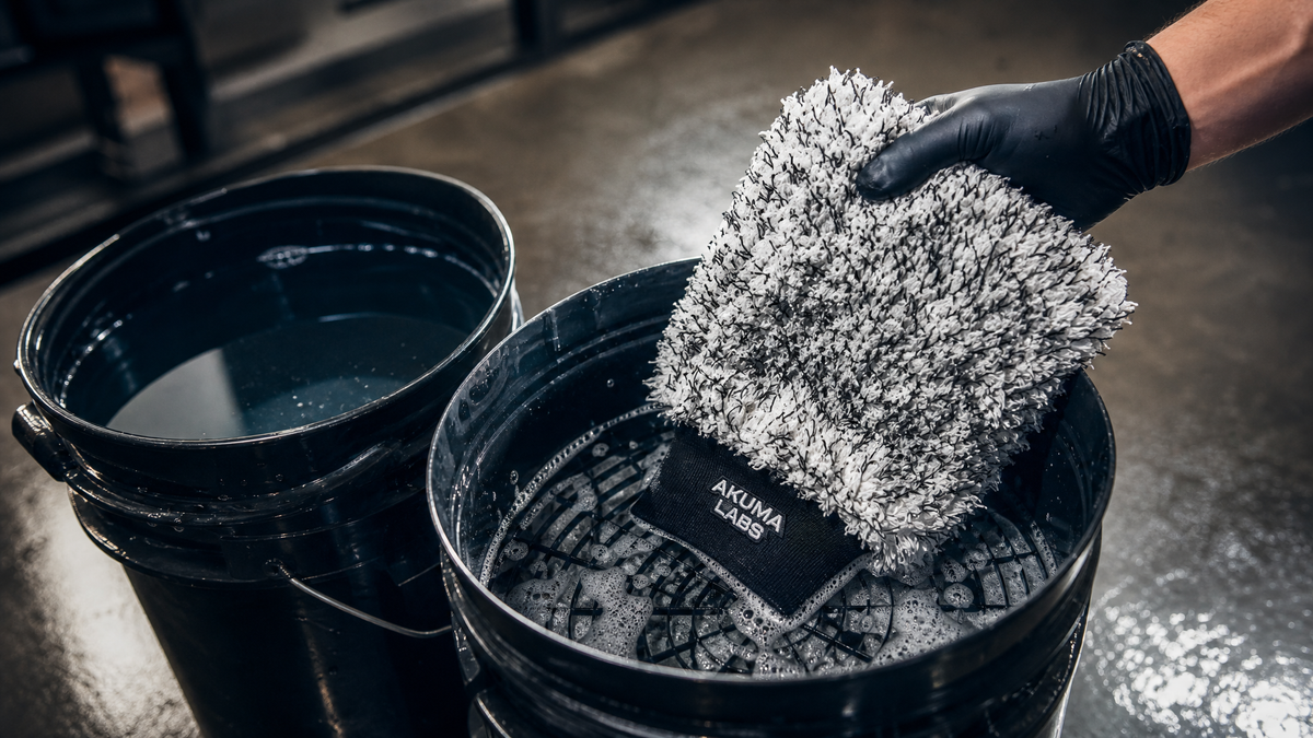 Yamako wash mitt being rinsed against a grit guard in the two-bucket method